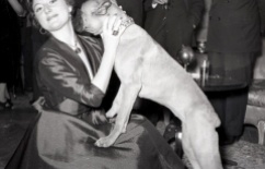 19 de marzo de 1954 Una invitada juega con la perra Chati en la fiesta de onomástica de José Campúa en su casa en el Paseo de Rosales (Madrid)